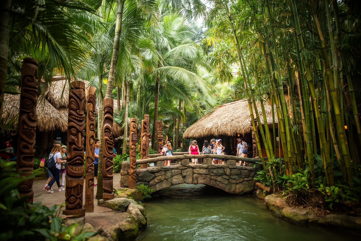 Magic Kingdom Hidden Gems: Secrets in Every Land Tiki carvings and thatched roofs along a shaded jungle walkway in Adventureland