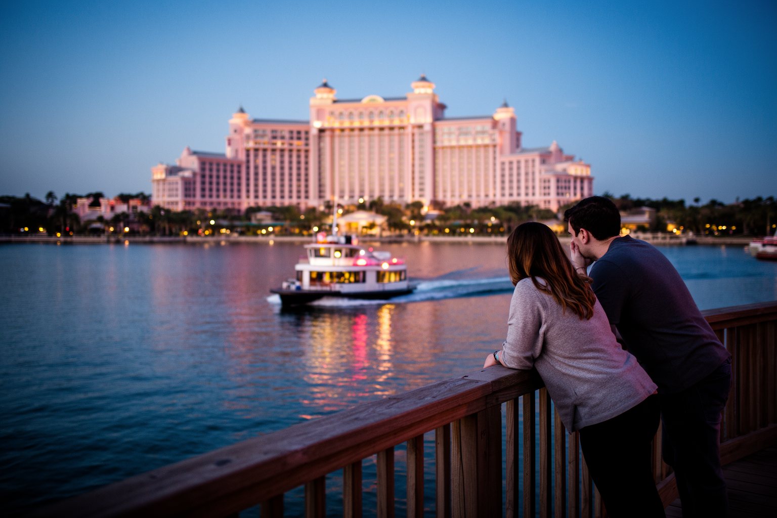 Discover the Magic: Top 10 Disney World Orlando Hotels You Must Visit! Couple watching a ferry cross the lake past lit Disney World resort hotels at dusk