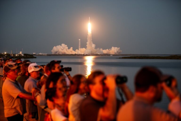 Kennedy Space Center Mars Missions: Road to the Red Planet Spectators on a Florida causeway watching a rocket launch from the Space Coast at dawn