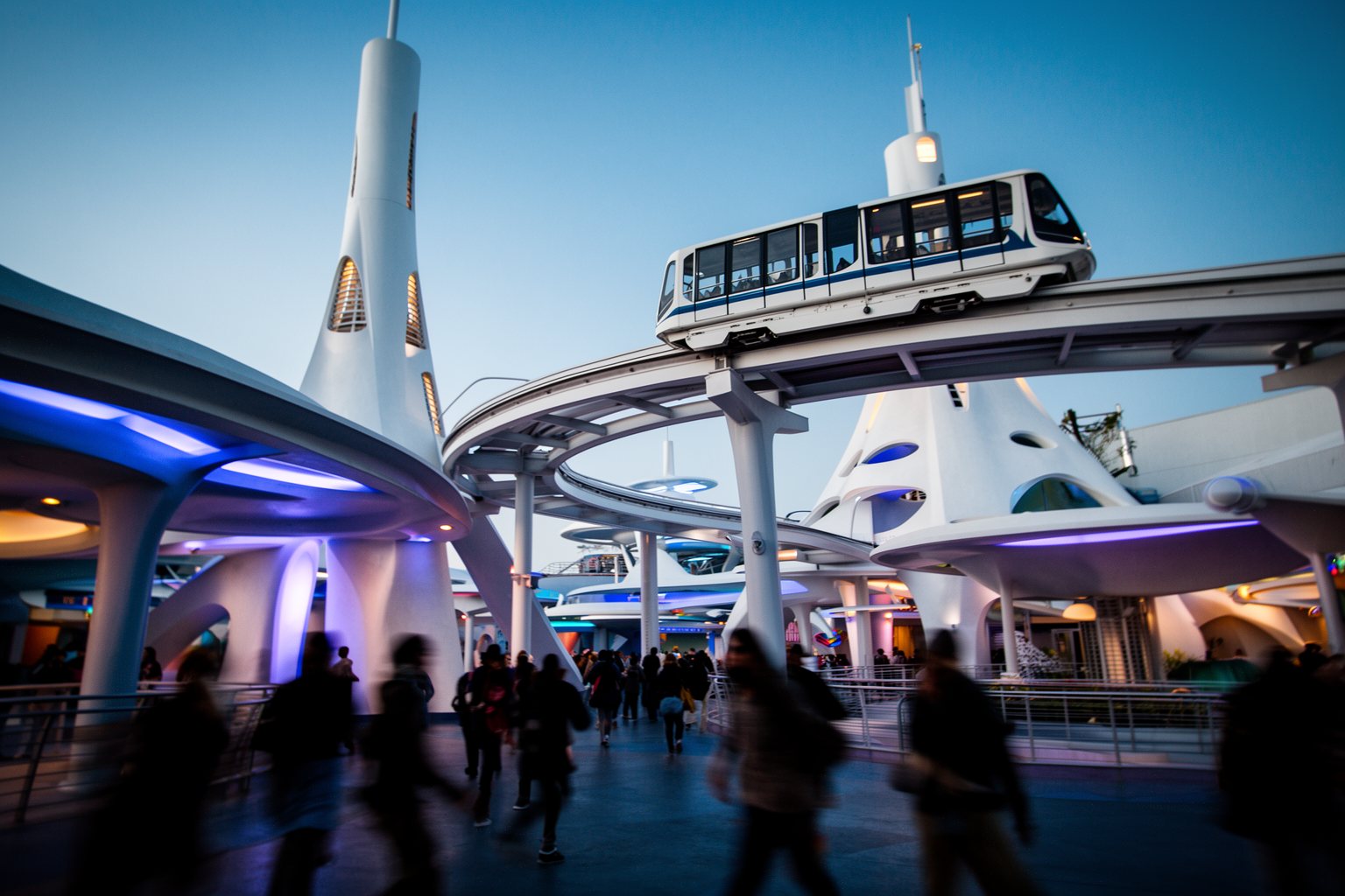 Magic Kingdom Hidden Gems: Secrets in Every Land Space-age towers and an elevated people mover glowing at blue hour in Tomorrowland