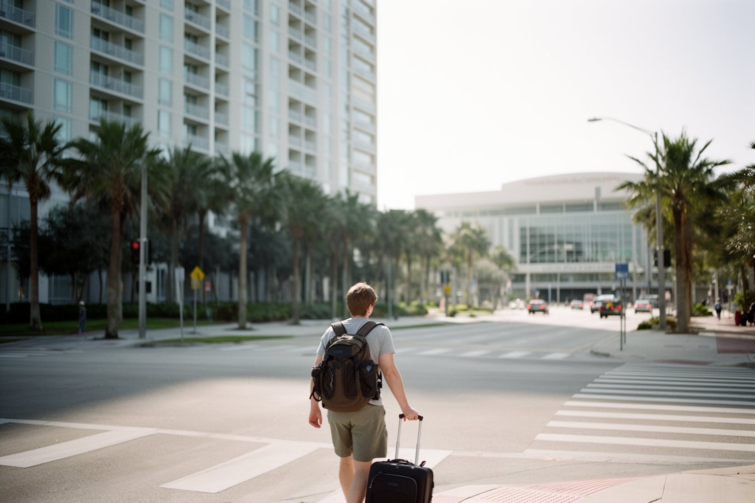 Traveler with a rolling bag outside a modern hotel near the Orange County Convention Center