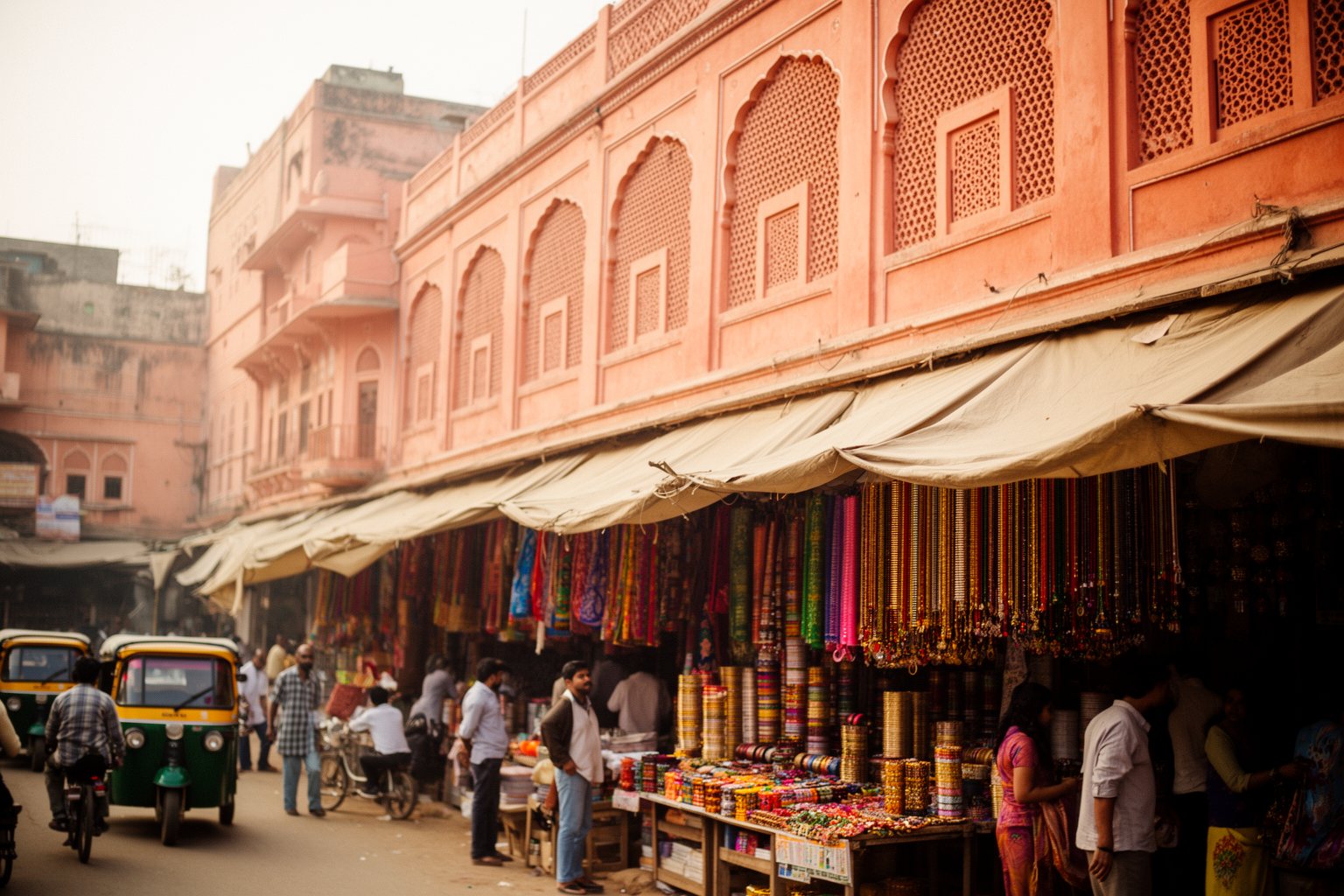 Busy bazaar street lined with pink buildings in Jaipur, India