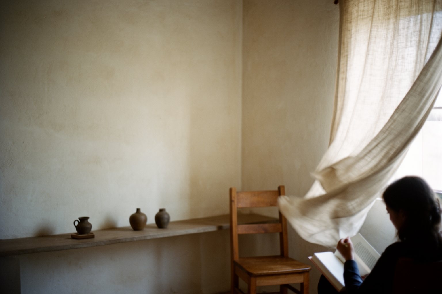 Simple uncluttered room with a single wooden chair and soft window light