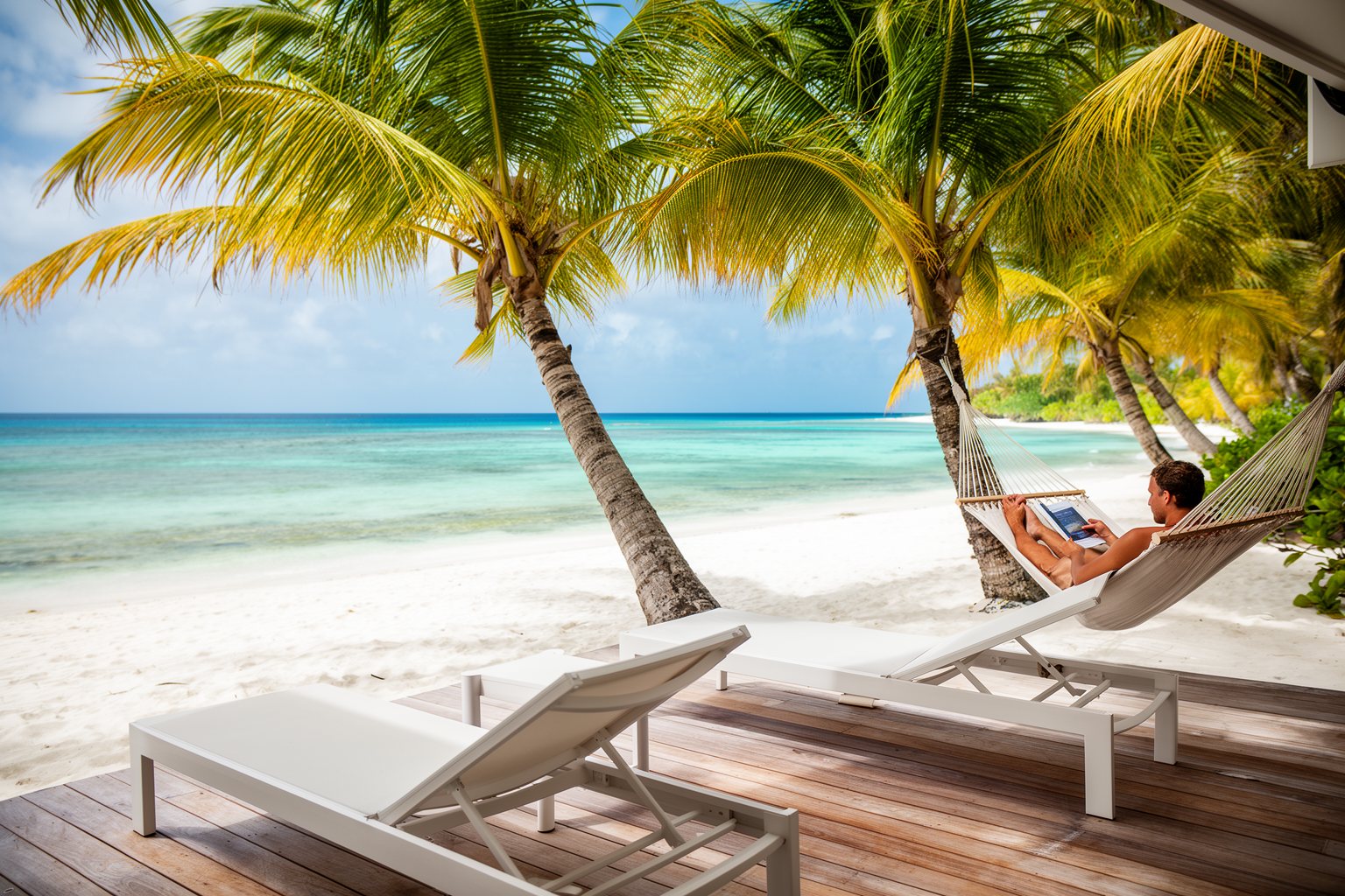 Private beachfront villa with palms and white sand in the Caribbean