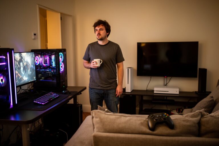 PC vs Console Gaming Cost: Which Is Cheaper Long Term? Living room with a gaming PC desk on one side and a console TV setup on the other