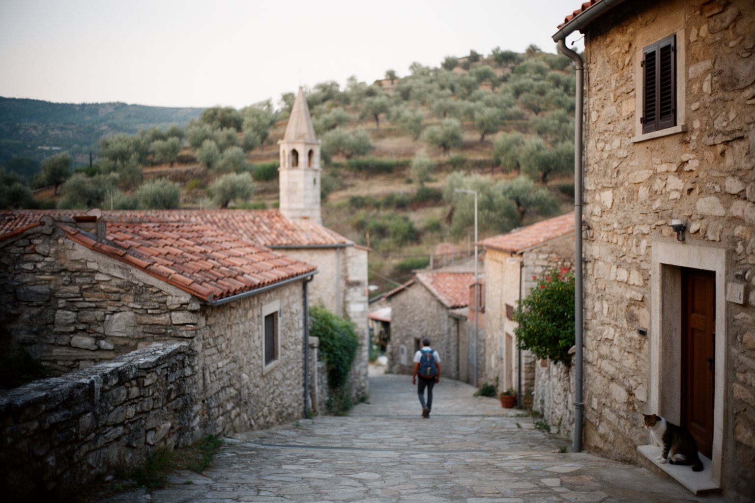 Unveiling the Top 10 Travel Hacks That Will Change The Way You Explore! Quiet stone hillside village off the beaten path with a traveler walking its empty lane