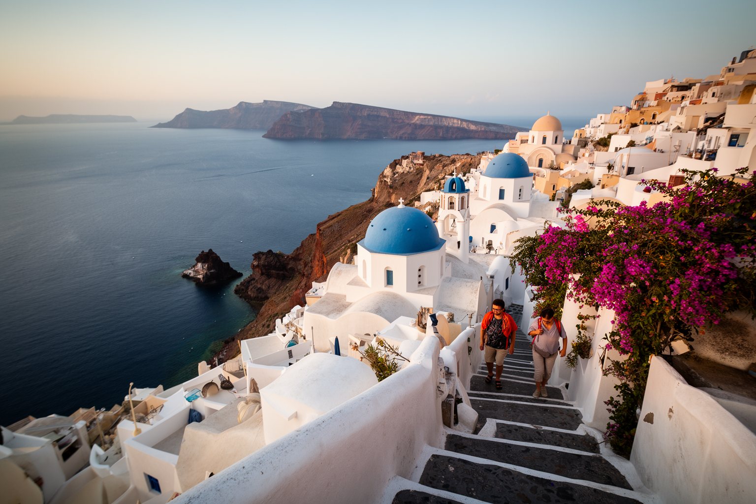 Unveiling the Top 10 Must-Visit Destinations: Your Ultimate Travel List Whitewashed houses and blue domes above the caldera in Oia, Santorini, in soft morning light