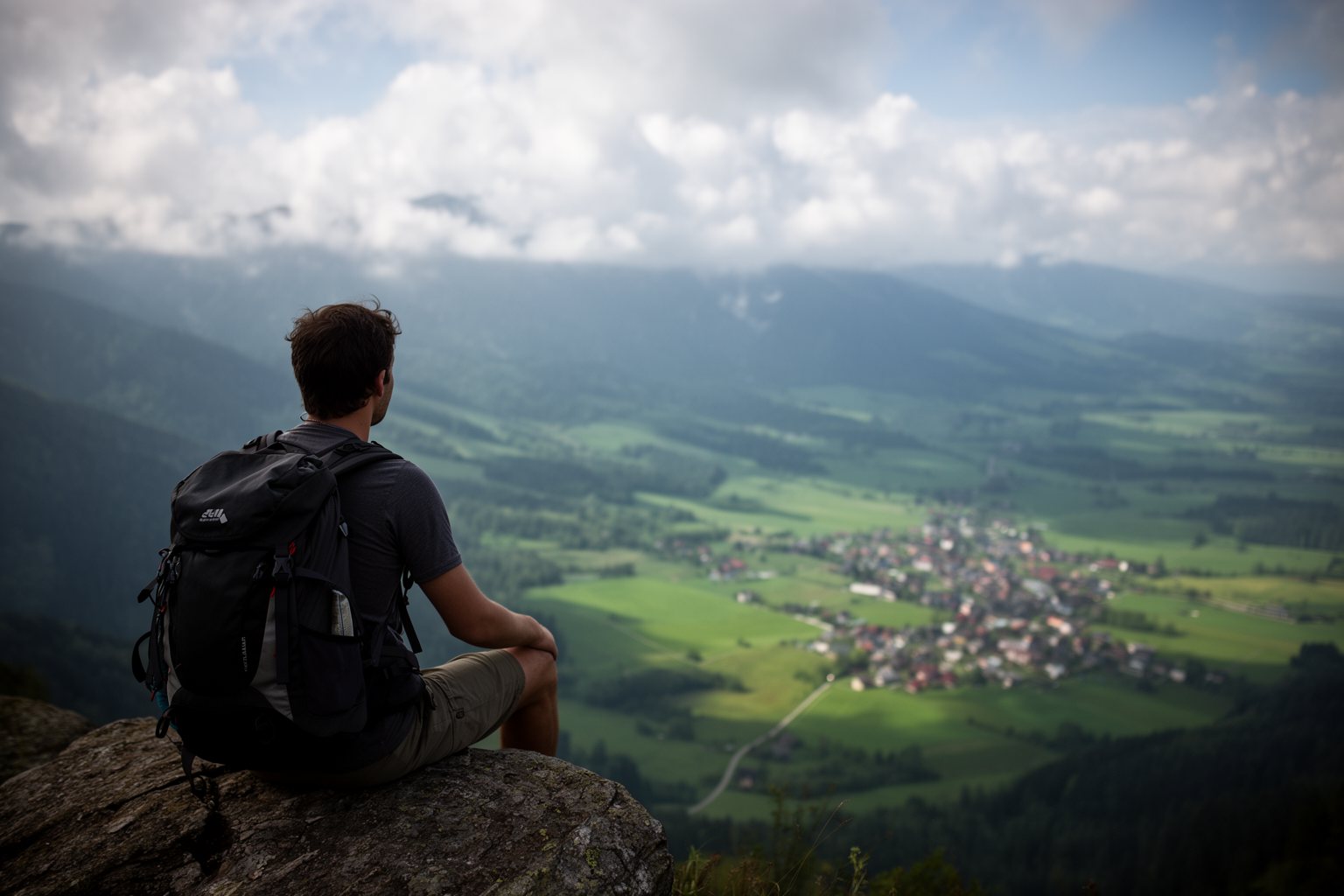 Unveiling the Top 10 Travel Hacks That Will Change The Way You Explore! Solo traveler with a backpack resting at a mountain viewpoint above a green valley