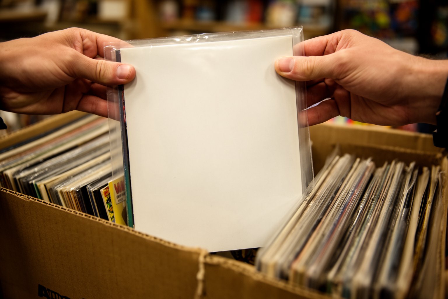 Unmasking Marvel: The Unexpected Evolution of Superhero Cinema Collector lifting a sleeved vintage comic book out of a longbox in a comic shop